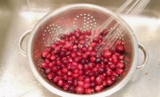 Die Beeren in ein Sieb geben und abspülen. Jetzt müssen Sie die Cranberries mit einem Löffel oder Stopfer in eine tiefe Schüssel mahlen, bis ein pürierter Saft entsteht.