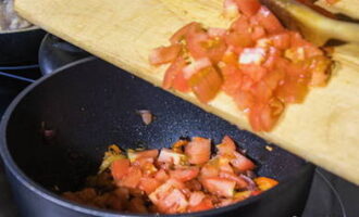 Dans une poêle à fond et parois épaisses ou dans un chaudron, faites chauffer l'huile végétale et ajoutez les tomates concassées avec les poivrons. Laisser mijoter les légumes à feu doux jusqu'à ce qu'ils soient tendres, en remuant constamment.