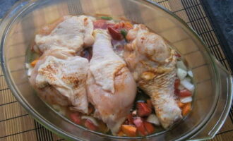 Next, sprinkle the chicken with chicken seasoning and spread it over the vegetables. Then fill everything with water at room temperature so that it covers the vegetables and rice.