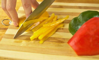 We also wash the bell pepper under running water. Next, remove the stem and seeds. Cut it into strips or cubes and place it in a bowl with cabbage, carrots and onions.