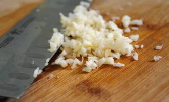 Rinse the hot peppers with water and chop as finely as possible. We also chop the peeled garlic cloves with a knife or using a garlic chopper. 