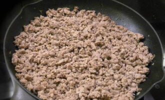 We send the minced meat to the same pan to fry. Add a little more vegetable oil and fry for about 10 minutes, breaking it up with a spoon. Let the finished minced meat cool slightly. At this time, grate the cheese on a coarse grater and finely chop the greens. Now we take a suitable container, put minced meat, fried zucchini with onions and garlic, grated cheese and herbs there. Add salt and black pepper to taste and mix well.