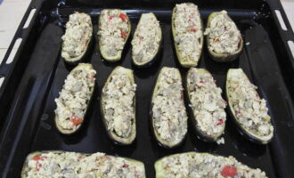 Place the zucchini boats on a baking sheet, lightly salt them and fill them with filling. Place chopped tomatoes on top and sprinkle with salt and pepper. Preheat the oven to 180°C and bake the stuffed zucchini for 30-40 minutes. 