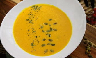 La délicate soupe à la crème de potiron selon la recette classique est prête. Versez dans des bols, décorez de persil séché et de graines de citrouille et essayez !