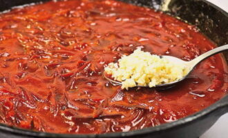 A continuación enviamos puré de tomate, remolacha pelada y rallada gruesa, pimiento picante, sal y azúcar. Vierta el resto del aceite en los ingredientes y cocine a fuego lento durante aproximadamente una hora. Después de 60 minutos, agrega los pimientos morrones y el ajo a la sartén. Continúe cocinando el aderezo a fuego lento durante 20 minutos. 2 minutos antes de que esté completamente cocido, vierta vinagre en la sartén. Mezclar el aderezo de borscht.