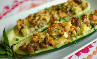 Sprinkle the prepared zucchini with grated cheese and place in the oven for 1-2 minutes until it melts. Place the finished boats on a serving plate, sprinkle with fresh herbs, and serve. Bon appetit!