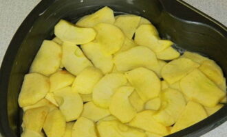 Peel the apples, cut out the seed pod and cut into arbitrary pieces or slices - place half of the fruit on the bottom of a baking dish, previously greased with a piece of butter.