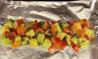 Tear off a piece of foil, lay it out and grease it with oil. Place half of the vegetables on the sheet and lightly sprinkle them with oil. 