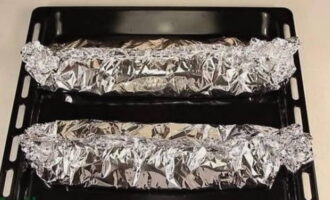 Cover the dish with the edges of foil. We do the same manipulations with the rest of the vegetables and half of the fish. 