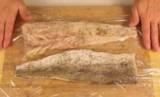 Salt the hake pieces on both sides. Wash the lemon, cut it in half and squeeze lemon juice from one part. Sprinkle it on the fish. Sprinkle the fillets with herbs de Provence and cover with cling film. 