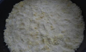 The first part is placed in a baking dish, kneaded well and the sides are formed. 