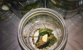 Sterilize jars for preparation in the microwave in advance. Immediately put washed greens, a peeled clove of garlic into each jar and add coriander and mustard seeds.