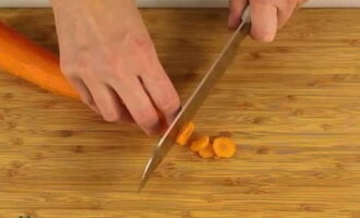 Peel the carrots (cut off the top layer with a knife) and rinse them thoroughly. Cut the root vegetables into slices.