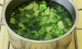 Dans une casserole sur le feu, portez à ébullition environ un litre d'eau, puis mettez les pommes de terre hachées et le brocoli dans l'eau bouillante. Cuire jusqu'à ce que les pommes de terre soient tendres – environ dix minutes. 