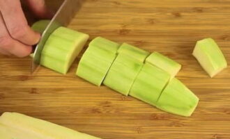 We wash the zucchini with water and remove the peel. If the zucchini is young, the peel does not need to be removed. Cut the ingredient into large pieces.