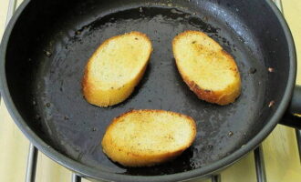 Smelt litt mer smør. Skjær baguetten i skiver en til en og en halv centimeter tykke. Stek skivene på begge sider til de er gyldenbrune. Gni inn hvitløk og salt etter steking, dryss med malt svart pepper.