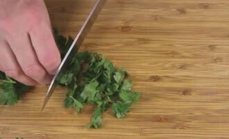 Rinse a bunch of parsley in water and shake until excess moisture is gone, and then finely chop with a knife.