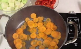 Pour half a glass of purified water into the pan. We put the dishes on the stove, which we then turn on. Place the carrots, cover the pan with a lid and simmer the product for 3 minutes.