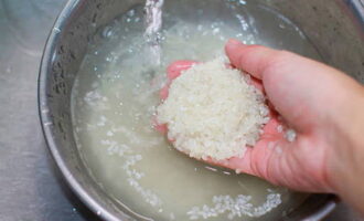 How to cook rice casserole in the oven? First, thoroughly rinse the rice under running water until it becomes clear.