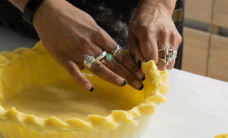 We cut off the excess dough with a knife and pinch the edges of the workpiece nicely. Pierce the dough with a fork.