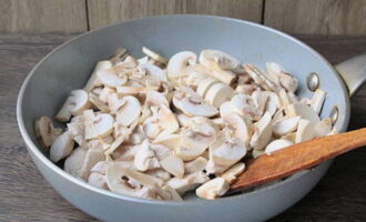 Now pour a tablespoon of lemon juice over the chicken and add the champignons cut into thin slices. Continue cooking over high heat, stirring constantly.