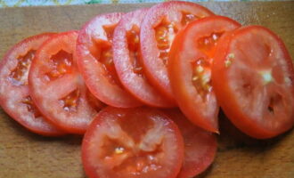 Was de tomaten grondig onder stromend water en droog ze op keukenpapier. Snijd vervolgens de steel eruit en snijd deze in cirkels van dezelfde dikte als de mozzarella.