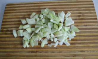 How to cook buckwheat with stew in a frying pan? First, we clean and wash the onions and chop them into small cubes.