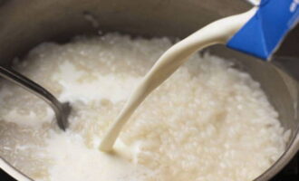 Return the rice to the pan and put it on the fire. Pour milk into it and bring to a boil. Cook the porridge over medium heat, stirring occasionally until it becomes viscous. Then remove from heat and let the rice cool to room temperature.