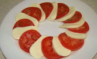 Now take a suitable round plate and place chopped mozzarella and tomato on it, alternating them with each other.