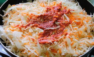 Add cabbage and carrots to the onions. Add tomato paste and a couple of tablespoons of water. Stir and simmer for about 5 minutes.