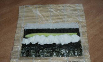 Carefully place the cream cheese on top of the nori and place the cucumber next to it.