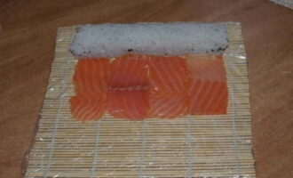 Then place the chopped red fish next to the roll. It can cover the entire surface of the roll or only three sides.