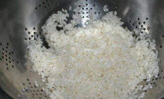 Rinse the rice thoroughly until the water is completely clear. Then place it in a colander to drain all the liquid.