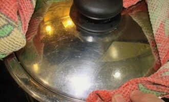 As soon as the contents of the pan begin to boil, close the lid and seal the edges tightly with a kitchen towel, preventing steam from escaping.