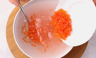 Dissolve the remaining salt in 350 milliliters of warm water, immerse the caviar in the solution for 15 minutes. Then drain it in a colander.