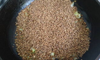 Place washed buckwheat in an even layer on top of the fried onions and sprinkle it with salt to your taste.