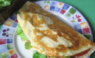 After frying, torn lettuce leaves are placed in each tortilla. Each flatbread is cut into two parts and served until it has cooled. 