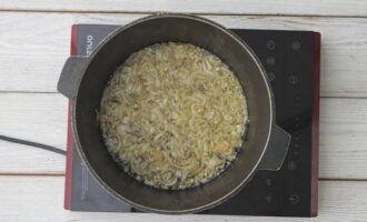 Now prepare zirvak for Uzbek pilaf. Place the chopped onion in the heated oil and fry it while stirring for 5-7 minutes until it turns dark golden in color, but does not burn.