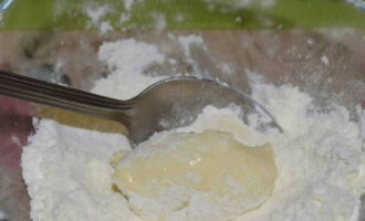 Using a teaspoon, scoop out a little dough and roll it in flour on all sides.