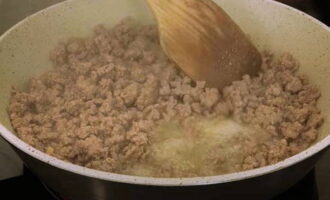 Then fry the minced meat in a frying pan in hot oil. Divide it into small pieces with a spatula, simmer over low heat and stirring until fully cooked. The minced meat releases its juice first, but fries quickly.