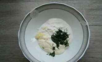 Let's prepare the sauce. In a bowl, mix sour cream, mayonnaise, chopped dill and garlic cloves passed through a press.