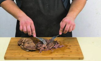 Afterwards, the beef is cooled and cut into thin strips, and then transferred to a deep bowl. 