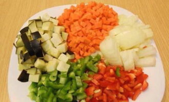 Hvordan laver man lækker couscous? Lad os først forberede grøntsagerne. Skær aubergine, peberfrugt, gulerødder og løg i små tern.