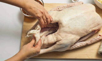 How to deliciously bake a goose with potatoes in the oven? First, thoroughly rinse the carcass under running water, then transfer it to a large container or sink, fill it with cold water and soak for three hours. Then we take out the bird, dry it with a paper towel and rub it with salt.