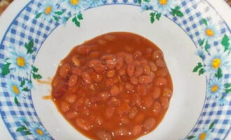 Salad with canned red beans is very easy to prepare. Open the can of beans and pour the contents into a deep plate.