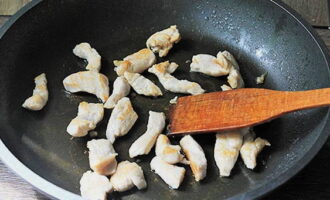 How to cook wok noodles with chicken and vegetables at home? Cut the chicken fillet into small pieces and fry in oil until golden brown.