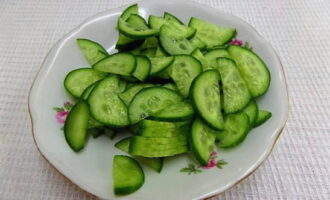 We cut the cucumbers into thin half rings, also salt them and put them in the refrigerator.