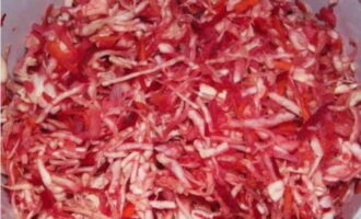 Transfer the shredded cabbage into a deep container, sprinkle it with salt, granulated sugar and knead everything well with your hands so that the juice comes out of the cabbage.