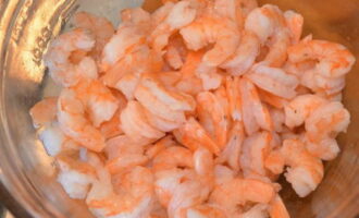 Place the finished shrimp in a colander, let them cool slightly, then clean them, removing the head, tail and shell. Then we put it on a plate. If the shrimp are large, you can cut them into 2-3 parts.