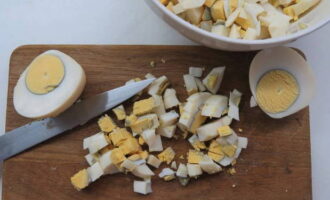 We peel the boiled eggs and grate them on a coarse grater or cut them into small pieces to make the cut of the roll look brighter.